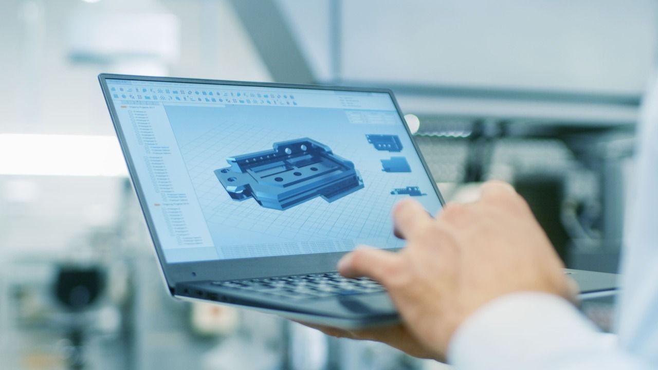 Industriedesign - Mann hält Laptop mit Designprogramm